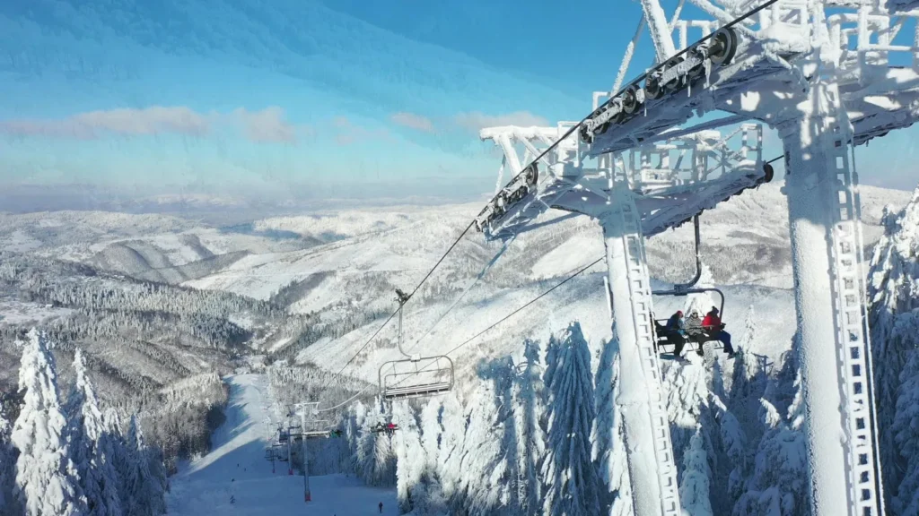 Sedačková lanovka nad zasneženou zjazdovkou v stredisku Snowparadise Veľká Rača